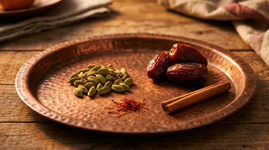 Cardamom, saffron, dates and a cinnamon stick on a hammered copper tray